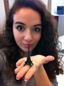 Julia holding a tiny, black 3D-printed Eiffel Tower.